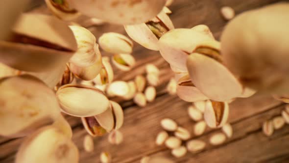 Super Slow Motion Shot of Fresh Roasted Pistachio Nuts Falling on Wooden Table at 1000 Fps