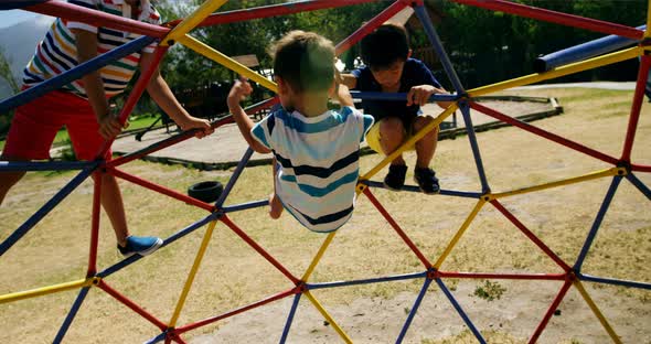 Schoolkids playing on dome climber in playground