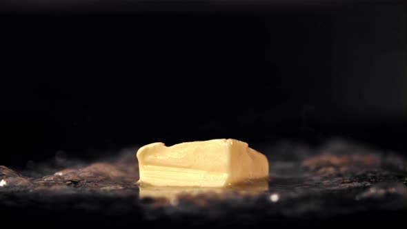 Super Slow Motion a Piece of Butter in a Frying Pan Melts with Hot Steam