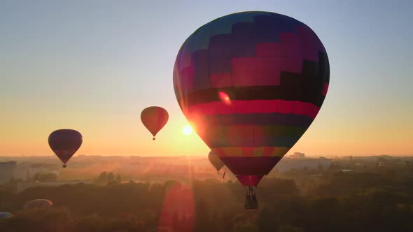 Aerial Drone View Silhouette of Colorful Hot Air Balloon Flying Over Green Park in Small European