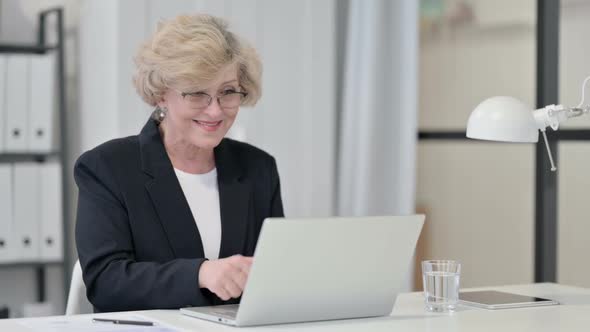 Old Businesswoman Celebrating Success While Using Laptop