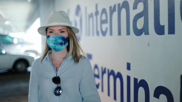 Stylish Traveler in Colorful Face Mask Is in Airport Parking Heading To Gates