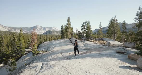 Drone Shot of Young Woman Taking a Photo with Professional Camera at Amazing Mountain Scenery in