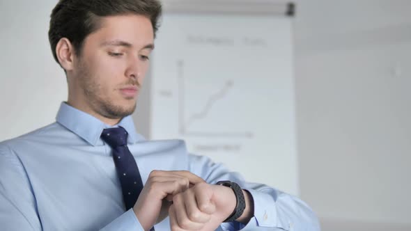 Close Up of Young Businessman Using Smartwatch at Work