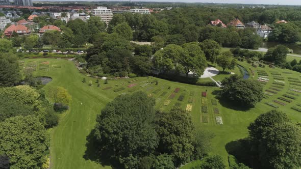 Drone Slowmotion of a Dutch Flower Garden in The Hague with Tourists and Seagulls passing, during Su