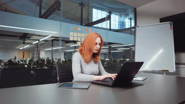 Red Haired Businesswoman Working on Report in Office