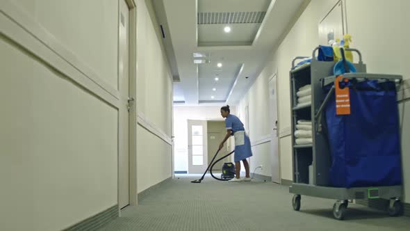 Housemaid Vacuuming Hotel Hall