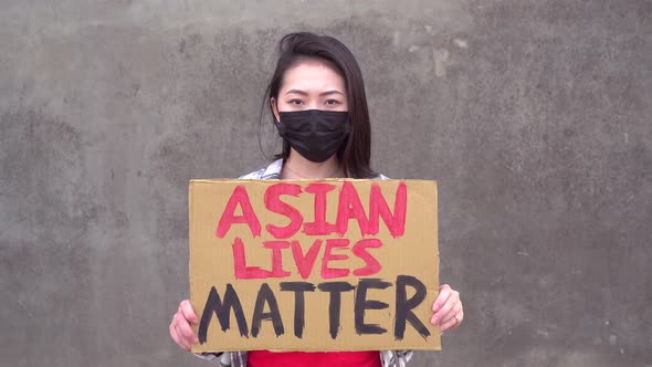 Asian woman with poster during protest against sexual harassment