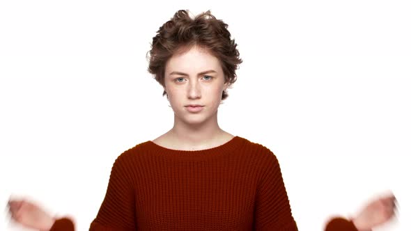 Portrait of Caucasian Woman in Red Sweater Being Perplexed Gesturing and Asking What Over White