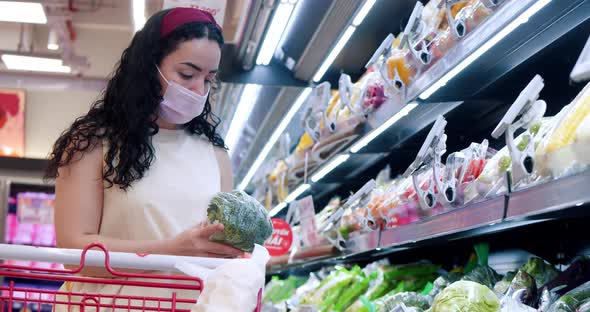 Woman Makes Purchases in a Supermarkethealthy Foodchooses Fresh Vegetables and Puts a Cauliflower in