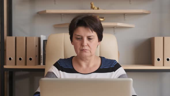 Woman Working on Laptop Computer. Doing Online Job in Home