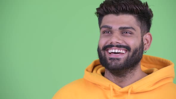 Face of Happy Young Overweight Bearded Indian Man Thinking