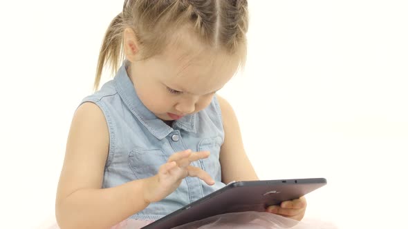 Little Girl in Her Hands Is Holding Aipad. White Background