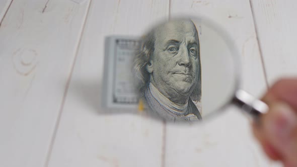 Closeup of Benjamin Franklin in a Magnifying Glass on a Hundreddollar Bill