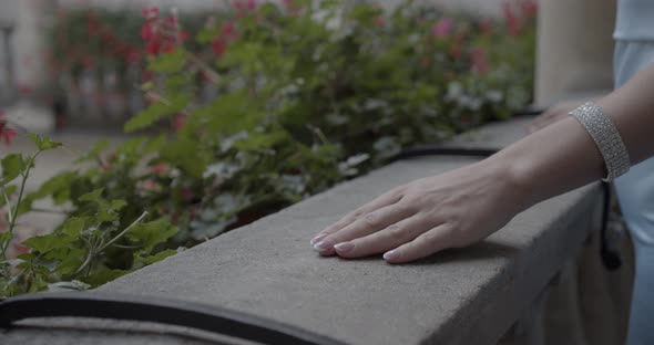 A Woman's Hand Adorned With A Bracelet Rested On The Railing