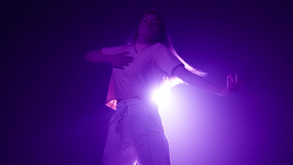 Professional Choreographer Woman Dancing Contemporary on Dark Background with Purple Light in Studio