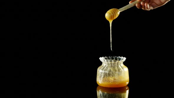 Honey being poured into a jar 4k