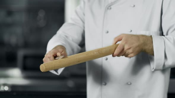 Man Chef Cleaning Up Roller at Workplace. Closeup Man Hands Preparing To Cook