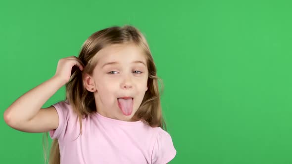 Child Teases, Shows the Language and Faces Merry Grimaces. Green Screen