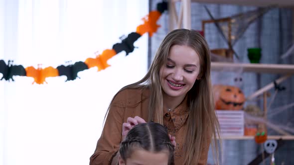 Young Beautiful Woman with Long Hair Braids the Braids of a Girl in a Room Decorated for Halloween