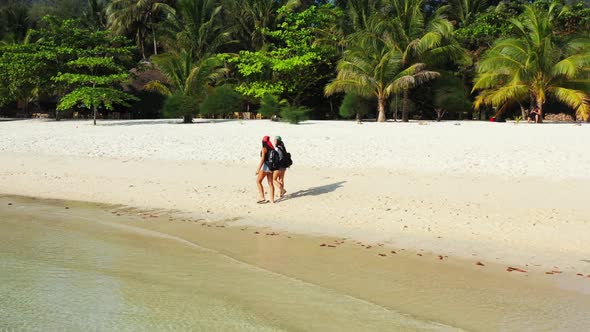 Women relaxing on luxury lagoon beach adventure by shallow ocean and white sandy background of Thail