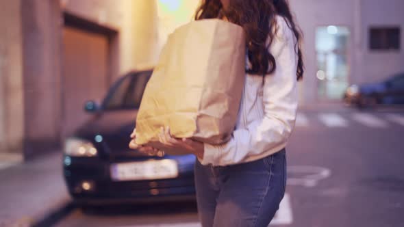 Girl Going Home Holding Brown Paper Bag With Products After Shopping