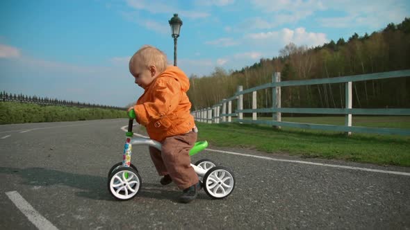 Little Kid Crossing Road on Bike in Slow Motion. Focused Boy Riding on Cycle