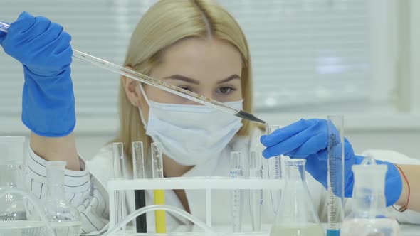 Female Doctor Analyzing Liquid In Test Tube