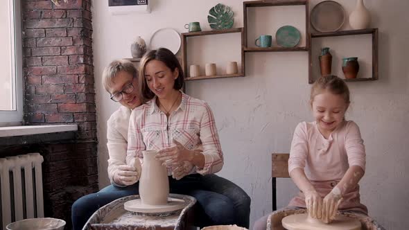 Little Kid Girl with Happy Family Working with Clay in Pottery w