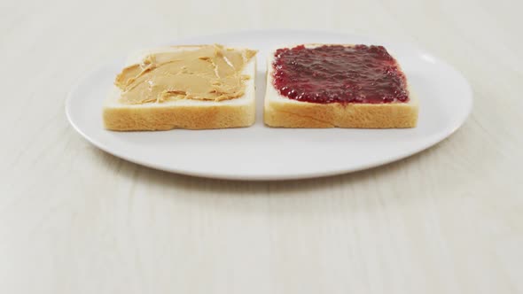 Close up view of peanut butter and jelly sandwich on wooden surface