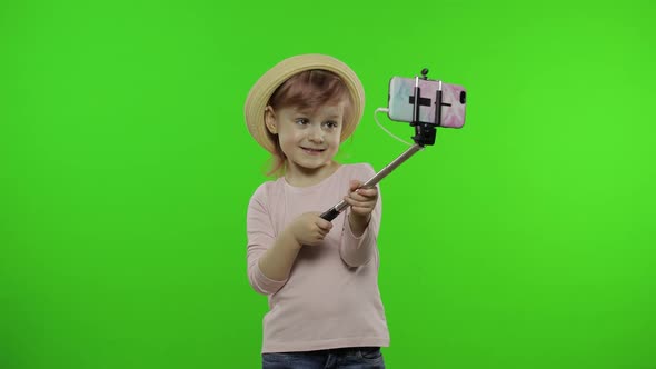 Girl Child Makes Selfie, Blogging on Mobile Phone Using Selfie Stick. Chroma Key