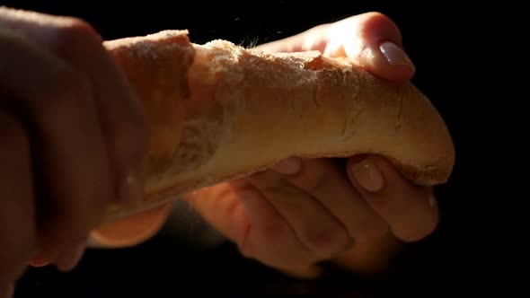 Hands Break a Bread Baguette