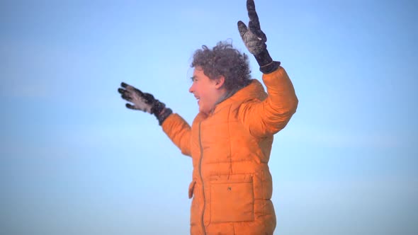 Close Up Portrait of Curlyhaired Boy in Winter Against Blue Sky Background