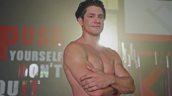 Portrait otanding in the dark of stadium. An active man shirf Caucasian young male athlete.