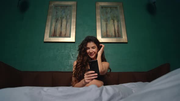 Sexy Girl Taking Selfie Mobile Phone Bed. Beautiful Woman Using Phone in Bedroom