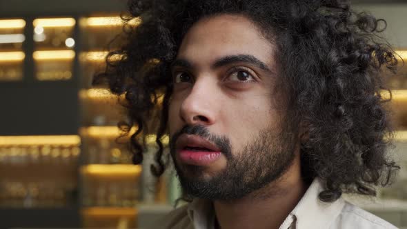 Confused Arabian Man with Kinky Hair Rubs Palms in Kitchen