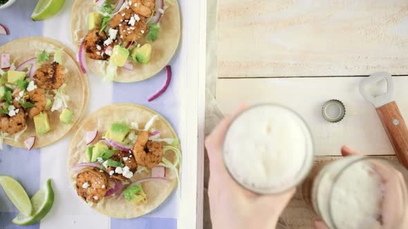 Fresh chipotle shrimp tacos with cotija cheese on a white corn tortillas.