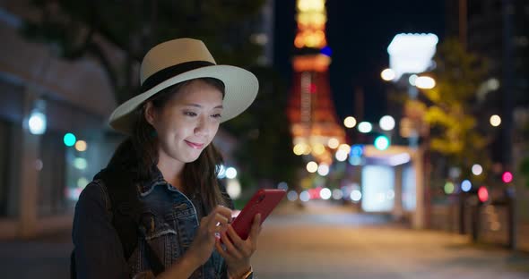 Woman use of mobile phone in Tokyo city at night 