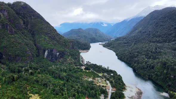 Aerial view truck right of Tagua Tagua Lake between its snowy and cloudy mountains, southern Chile.