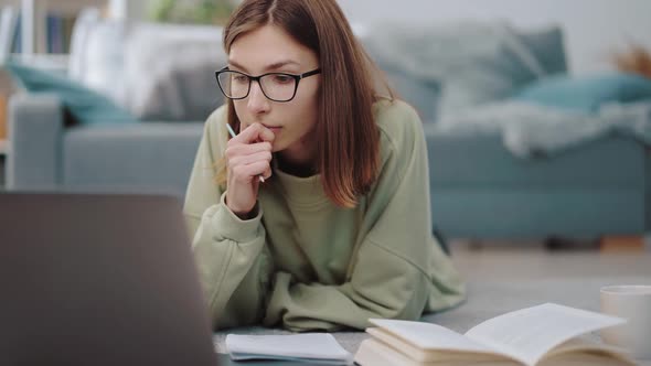 Thoughtful Woman Studying on Laptop at Home