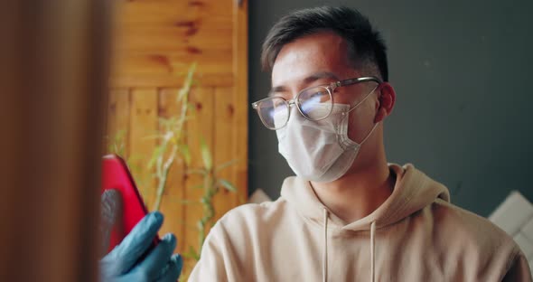 Asian Man in Quarantine for Coronavirus Wearing Protective Mask with Filter He's Working From Home