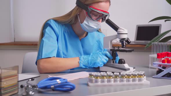 Woman Laboratory Worker Looking Into Microscope
