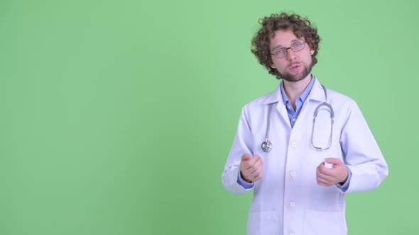 Happy Young Bearded Man Doctor Touching and Presenting Something