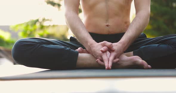 Slim Man Doing Yoga Exercises in City Park Outdoors