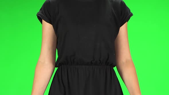 Female Body Close Up in Walking. Girl with Blond Hair in a Black Dress on a Green Screen. Slow