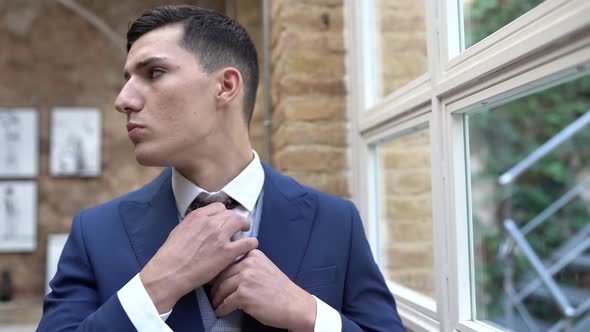 Portrait of groom looking out of the window