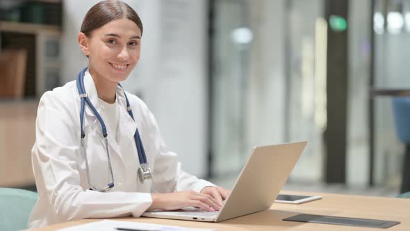 Friendly Female Doctor with Laptop Smiling in Office 