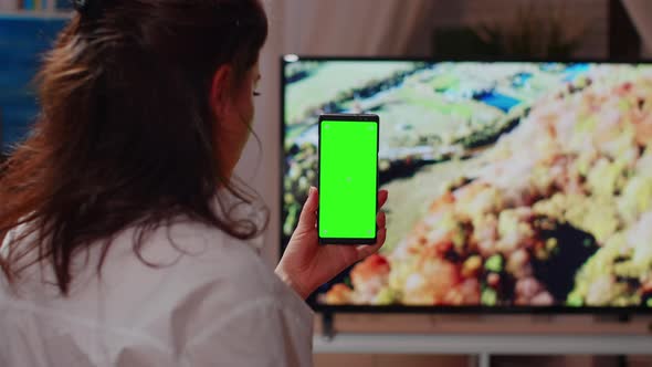 Young Adult Looking at Smartphone with Green Screen