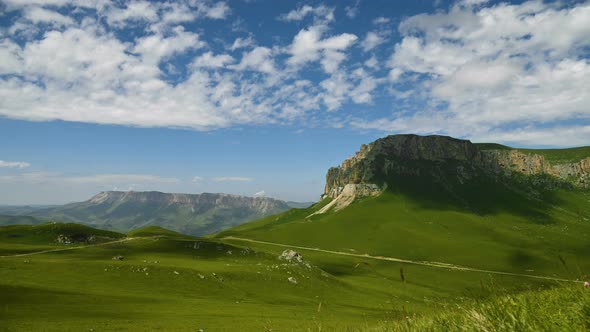 Timelapse of a Beautiful Green Highlands Daytime Summer Landscape of a Rocky Plateau and Clouds and