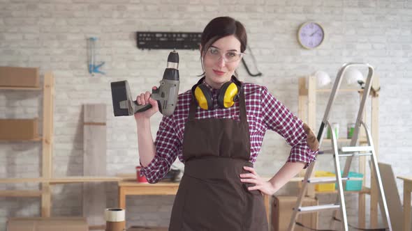 Portrait Professional Young Worker Carpenter Woman with an Electric Drill